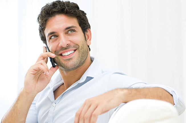 Man smiling on the phone without the pain of TMJ or TMD
