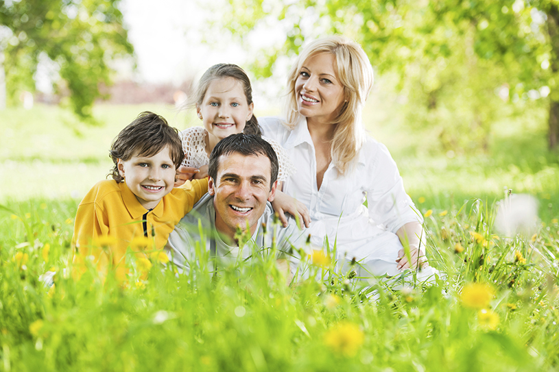 Family enjoying the park with healthy teeth thanks to regular fluoride treatments